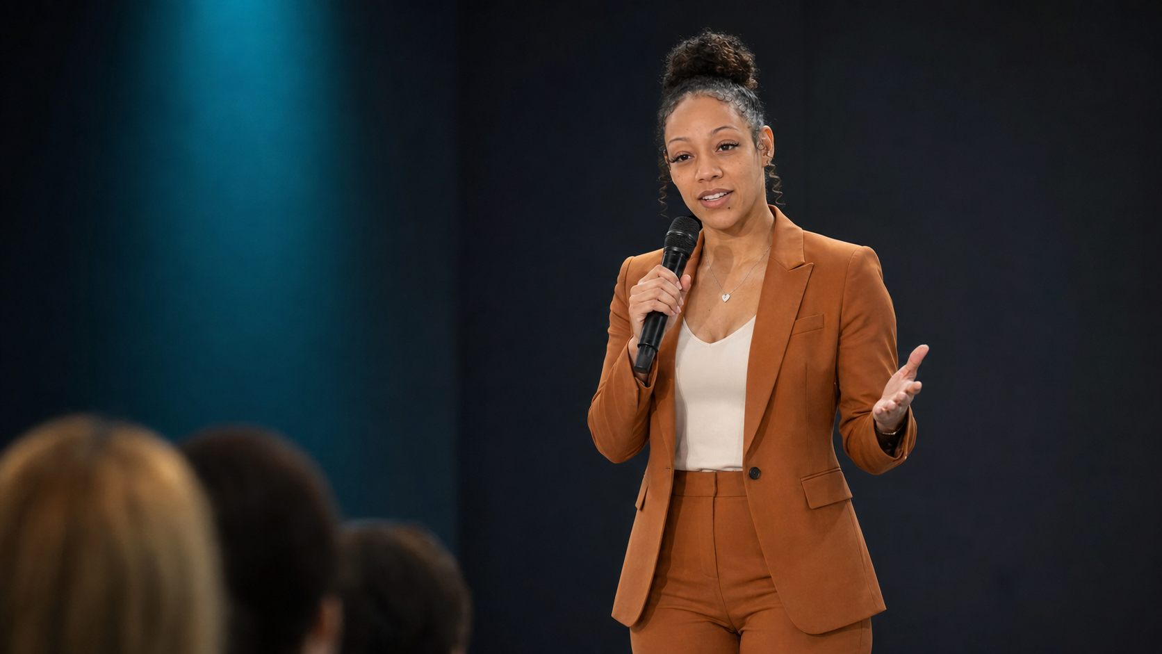 Mia Stokes speaking to an audience in the approved speaker photograph